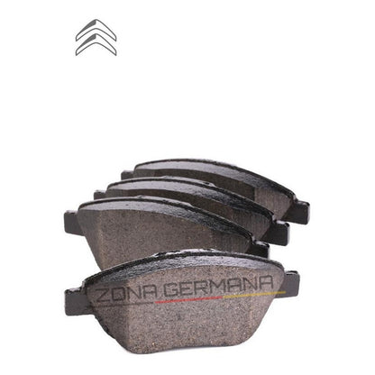 Set of four automotive brake pads for Citroën on white background